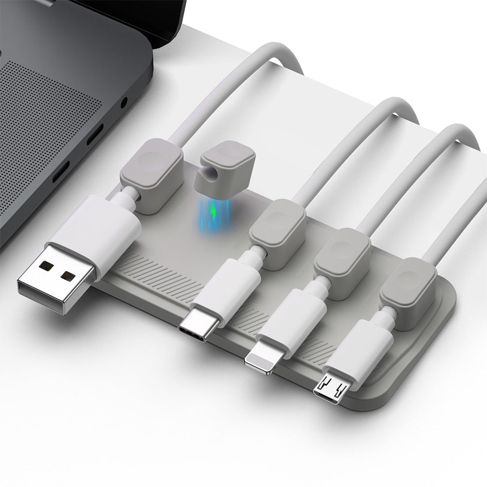 4244464e63ee785af1f85c2c6e1b26c4Charging cable wire holder with multiple ports for organized cable management on a desktop.