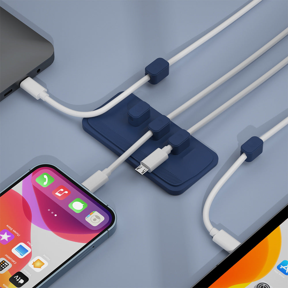ab8ace2bf63df2ba7a675b764db0332cCharging cable wire holder with multiple ports for organized cable management on a desktop.